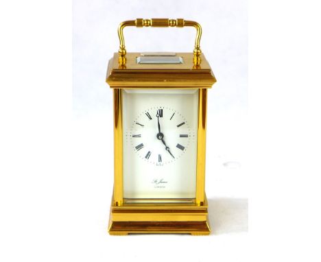 A reproduction brass cased carriage clockBy St James London, the white enamel dial having Roman numerals with swing carrying 
