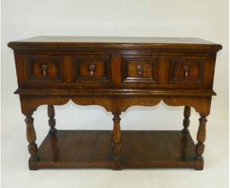A good quality reproduction 17th Century style dresser baseThe planked top above two panelled drawers with brass drop handles
