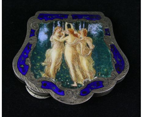 A continental white metal and enamel compactPossibly Italian, of shell form, the enamel lid depicting three classical female 