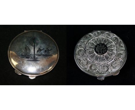 A continental white metal and niello enamel compactPossibly Russian, of circular form, the lid with intricate filigree detail