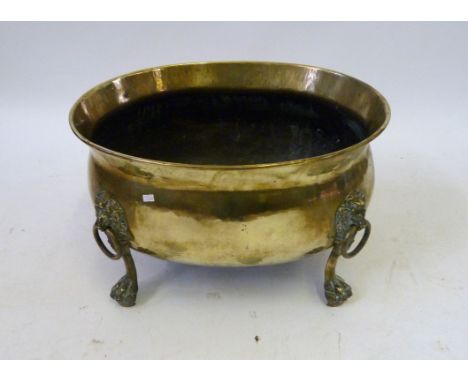 A Regency style brass planter/log container, 20th CenturyThe oval shaped container with lion's mask and rings, raised on lion