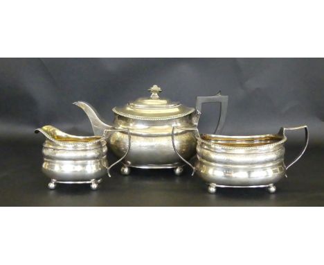 A George III silver three piece tea serviceOf shaped ovoid form, with applied gadroon rims, engraved with alternating shell a