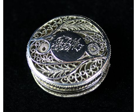 An unusual George III silver patch boxOf circular form, the pull-off lid with fine filigree decoration centering a circular i