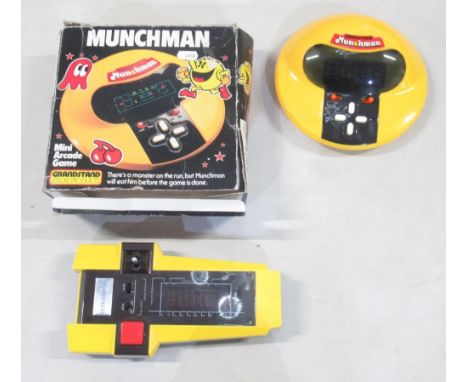 Two vintage hand held computer games, comprising Grandstand Munchman with box, and a CGL Galaxy Invader 1000 with instruction