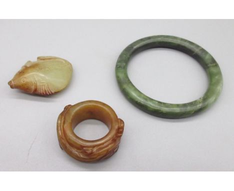 Chinese jade archers thumb ring carved with two dragons, a carved jade fish pendant and a polished green jade bangle (Victor 