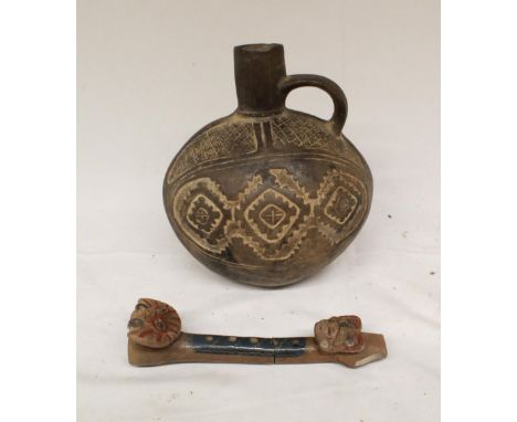 A small embossed ceramic jug in the Indo-Peruvian style. Accompanied by a ceramic flute in the same style. (Victor Brox colle