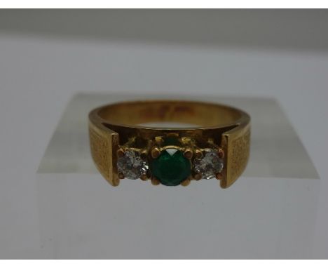 An 18ct gold, diamond and emerald three stone ring, weight 5.5g, size M