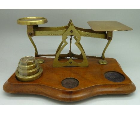 A set of brass postal scales and weights on shaped mahogany base