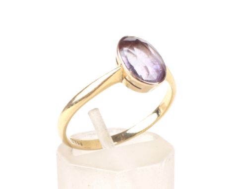 An amethyst single stone ring. The pale-violet, oval mixed-cut stone approx. 1.45cts, rub-over set in yellow on a 'D' section