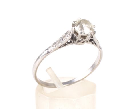 An early-mid 20th century platinum and diamond solitaire ring with small diamond shoulders. The principle transition-cut ston