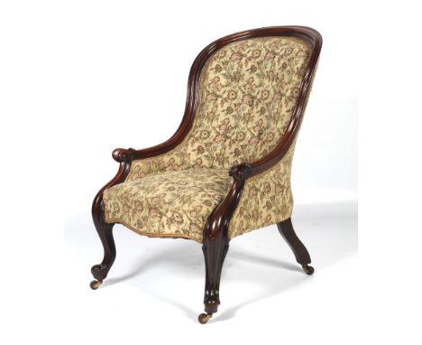 A Victorian mahognay framed spoon button back elbow chair. With scrolled arm rest leading to carved cabriole and ball front s