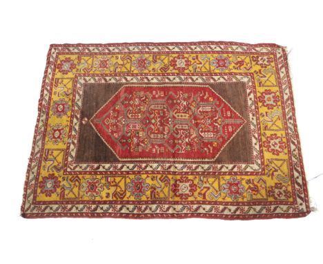 An Eastern blended wool rug. With central medallion on a red and brown ground with multiple borders of geometric design with 