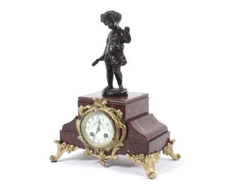 A French red marble and gilt-metal mounted mantle clock. With bronzed figural finial, the ivorine dial painted with flowers, 