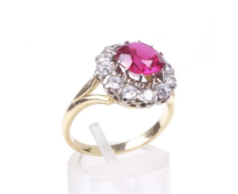 A synthetic-ruby and near-colourless sapphire cluster ring. Centred with a round mixed-cut synthetic-ruby approx. 8mm diamete