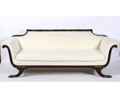 An Edwardian ebonised frame re-upholstered sofa in cream, with carved top rail and scrolled out swept arms. The front frame w