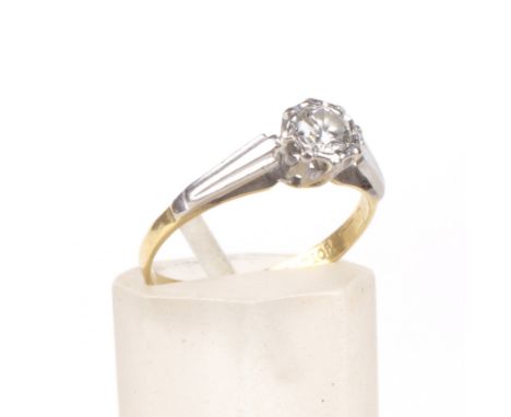 A mid-20th century gold and diamond solitaire ring. The round brilliant approx. 0.23cts, illusion set in white between tapere