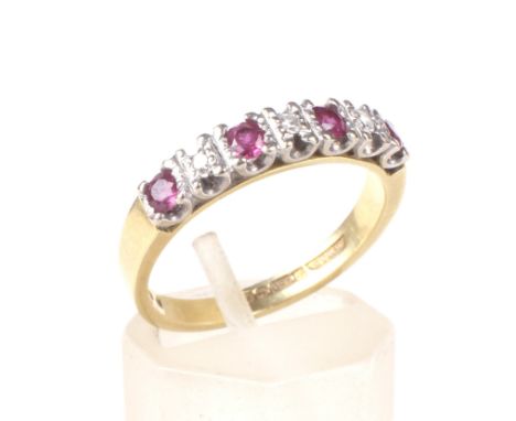 A vintage 18ct gold, ruby and diamond seven stone half-eternity ring. The four round mixed-cut rubies spaced by small eight-c