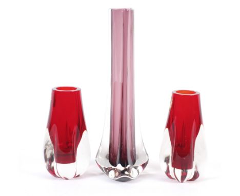 Three Whitefriars vases. Comprising a pair of Whitefriars ruby red bud vases with label and a Whitefriars amethyst triangular