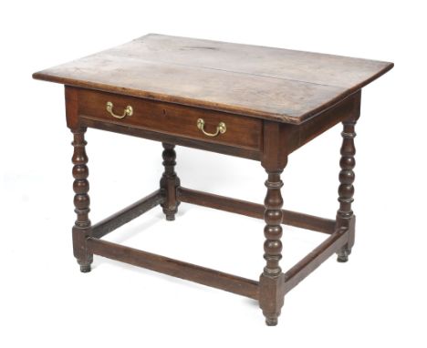 A 19th century oak plank top table. The top raised on bobbin turned supports united by all round stretches on bun feet. L98cm