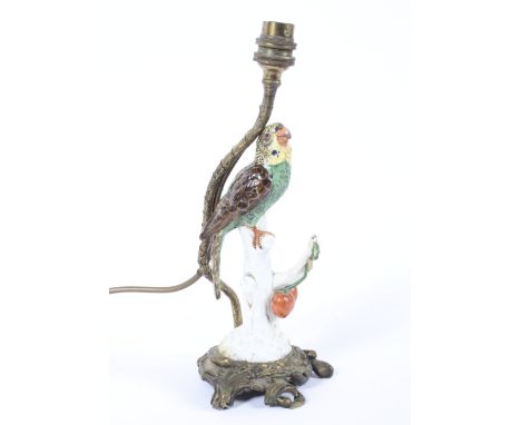 A Continental porcelain Meissen-style parrot and gilt-metal mounted table lamp. The yellow and green parrot perched before ch
