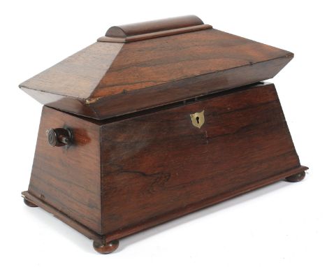 An early 19th century rosewood sarcophagus-shaped tea caddy. The domed and canted hinged cover revealing a later baize-lined 