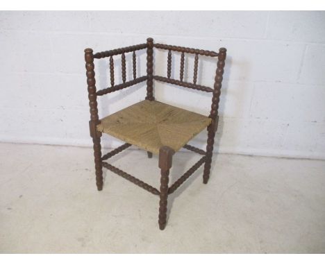 A rush seated bobbin turned oak corner chair.