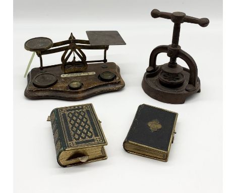 An assortment of items including vintage postage scales and weights, two gilt edged prayer books, inlaid Edwardian inkwell et