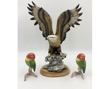 A large ceramic eagle on wooden base signed A Balarci along with two lovebirds by Goebel 