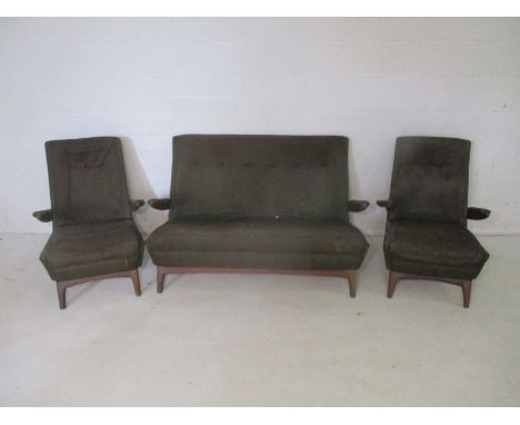 A mid century three piece suite, comprising of a sofa and two arm chairs.
