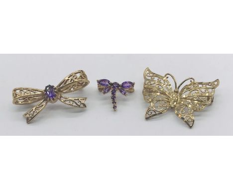 Three 9ct gold brooches, a butterfly, a bow with central amethyst and an amethyst dragonfly- total weight 7.3g