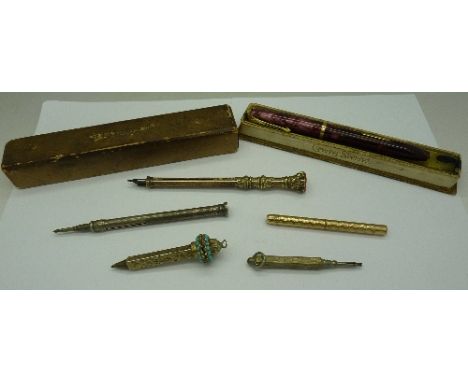A collection of five pens/pencils including a gold plated dip pen with seal, a silver pencil with calendar and a boxed Conway