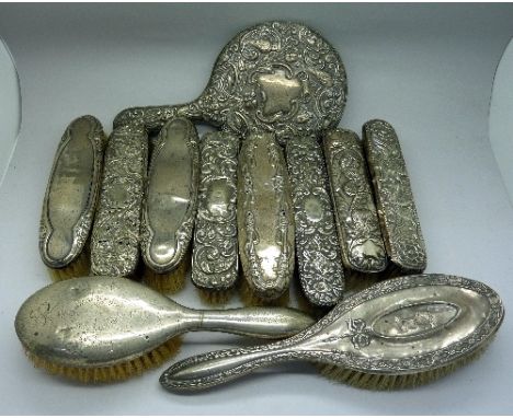 Seven silver backed brushes, a silver backed mirror and four other silver backed brushes including one pair