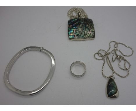 A silver bangle, two silver pendants and chains and a silver ring