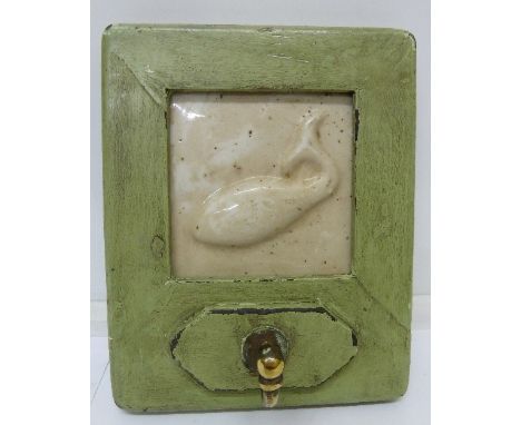 A ship's cabin coat hook with whale tile plaque