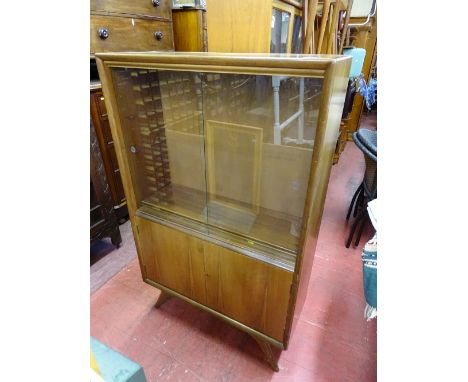 Compact mid Century bookcase cupboard with twin sliding glass doors over base cupboards