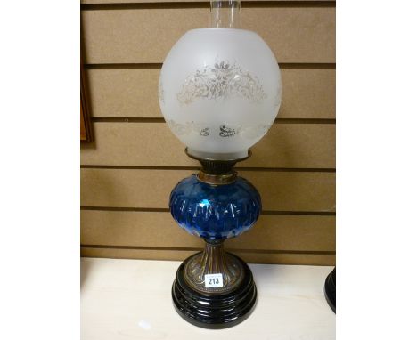 Metal stemmed oil lamp with blue glass reservoir and etched shade