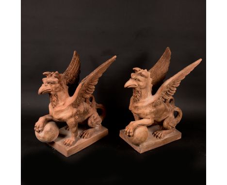 Pair of terracotta griffins, each with wings, holding a bowl, on rectangular integrated bases; light red terracotta sculpted;