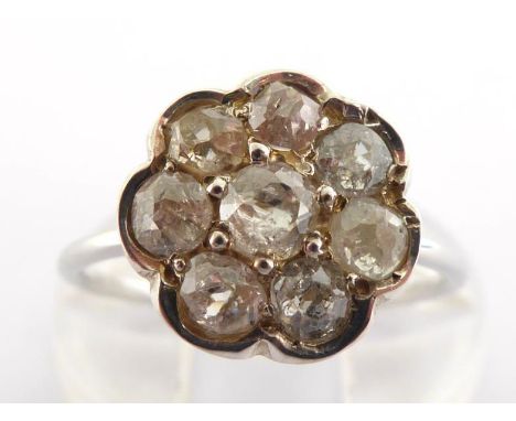 A diamond daisy cluster ring, set with old mine cut stones, to a slim white metal (tests platinum) shank, finger size L, 2.1g