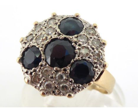 A 9 carat gold, sapphire and diamond plaque ring, the circular cluster composed of four sapphires, the largest 5mm diameter, 