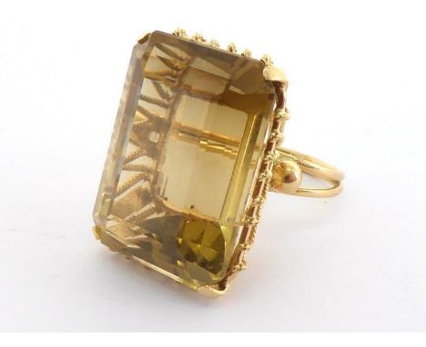 A citrine dress ring, the large emerald cut stone 23 x 17mm, mounted in yellow metal (tests 14 carat gold), finger size K, 12