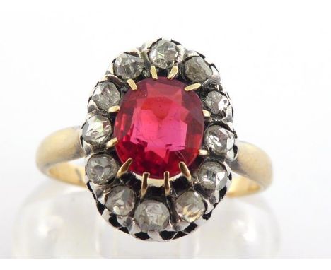 A French 18 carat gold, diamond and synthetic ruby cluster ring, the central oval cut Verneuil stone 7 x 5mm, in a surround o