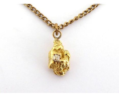 A yellow metal (tests 14 carat gold) and diamond nuggest pendant, the small brilliant claw set above the body of the nugget, 