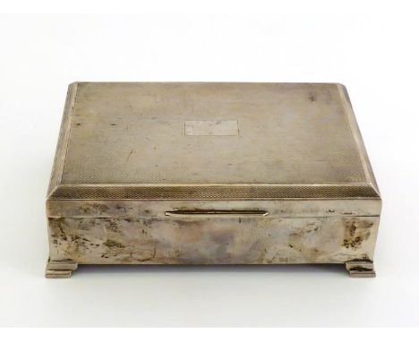 A silver cigarette box, Birmingham, 1954, on stepped bracket feet, engine-turned cover with vacant reserve, cedarwood-lined a