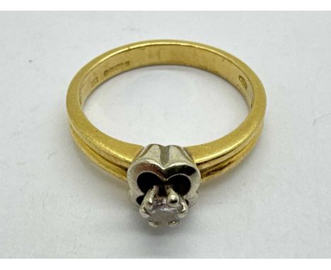 An 18ct Gold Single Stone Diamond Ring, circular high claw set within flowerhead style frame, between uniform reeded band (fi