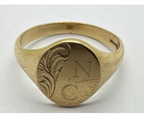 A 9ct Gold Gent's Signet Ring, the oval panel engraved "NC", with partial scrollwork decoration, between wide tapered shoulde