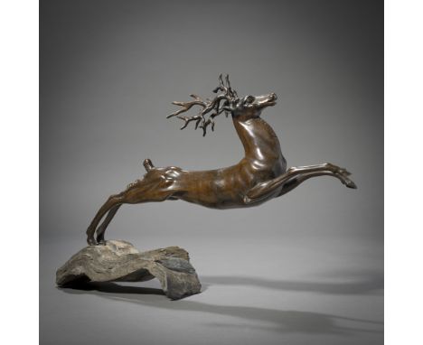 Springender Hirsch20. Jhdt.29 x 42 cmBronze, patiniert, auf welligem Steinsockel. Min. ber.