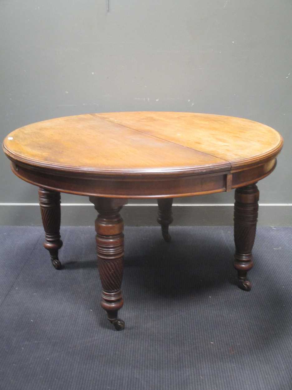 A late Victorian walnut extending dining table, with an extra leaf and