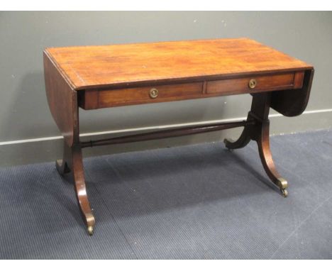 A Regency mahogany sofa table, the rounded rectangular top with drop end leaves, the frieze fitted with two drawers, on splay