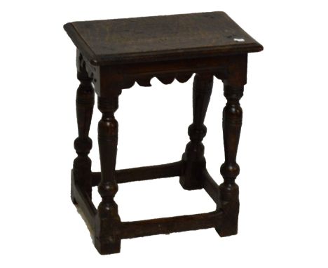 An 18th century oak joint stool, rounded rectangular top above a shaped frieze and ring turned legs to block feet united by s