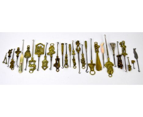 A quantity of mainly brass novelty and souvenir button hooks, including three trench art hooks with bullet handles, others in